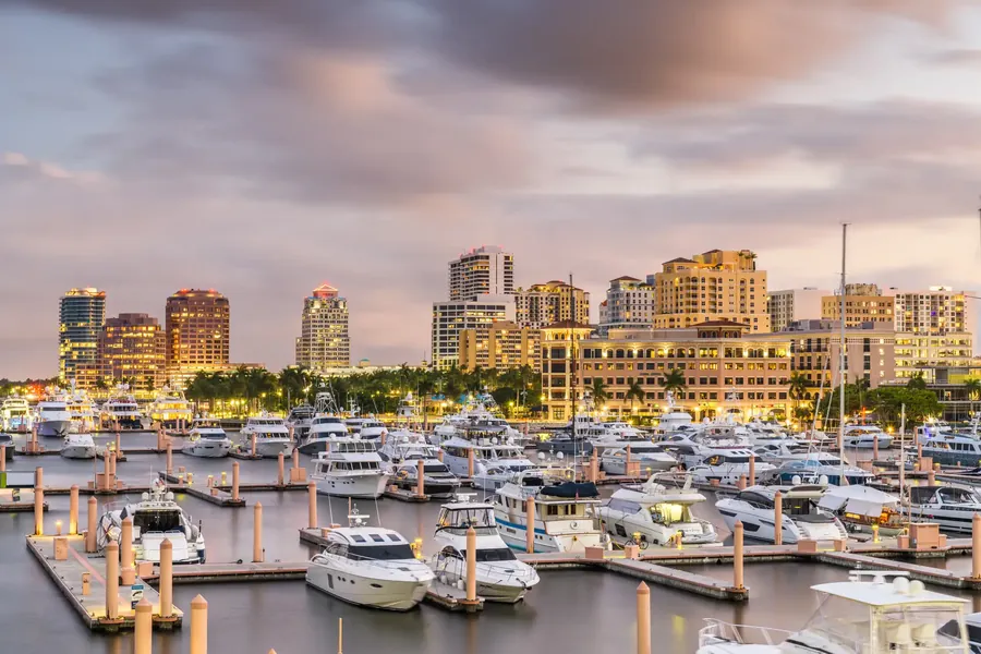 Die Skyline von West Palm Beach über das Wasser mit Palmen und einer Marina