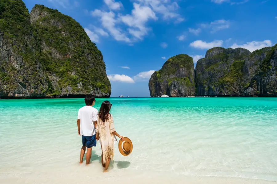 Ein Paar an einem weißen Strand zwischen Kalksteinfelsen