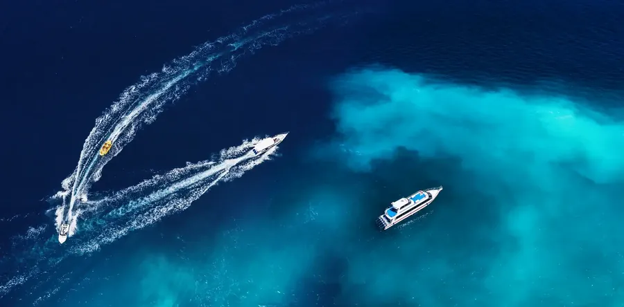 Schnellboote auf tiefblauem Meer vor Bali, von oben gesehen