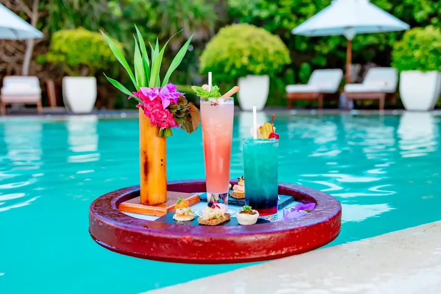 Cocktails auf einem schwimmenden Tablett in einem tropischen Pool