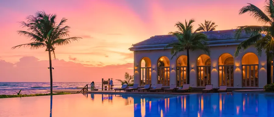 Ein Resortpool bei Sonnenuntergang auf einer tropischen Insel